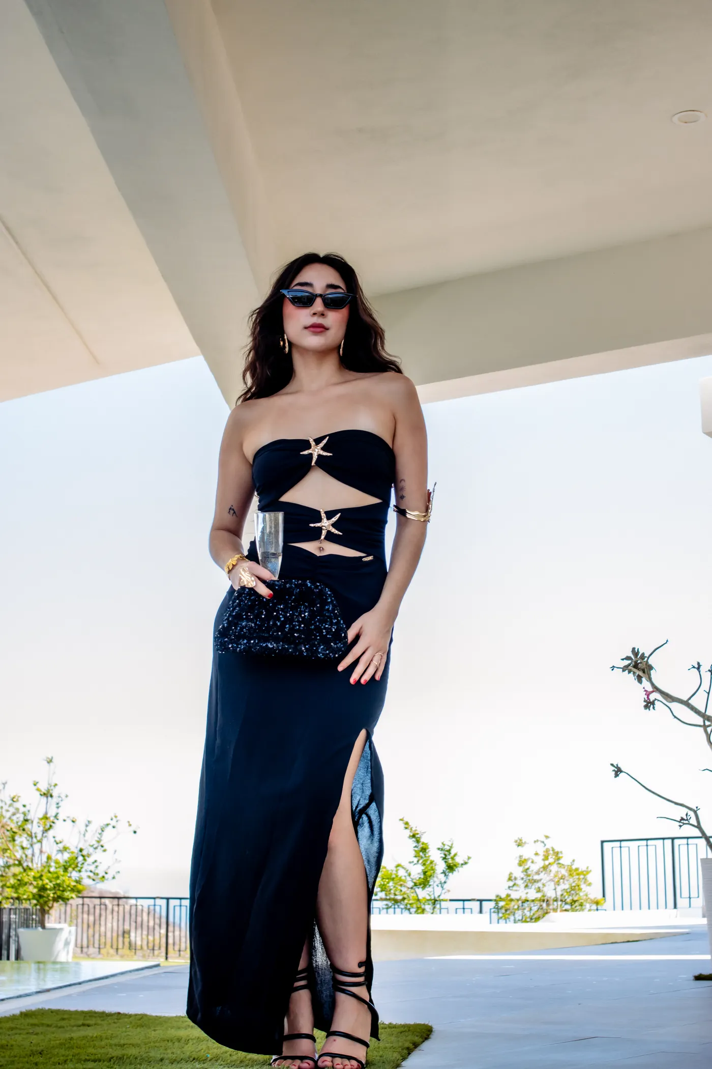 Modelo con vestido negro y accesorios dorados